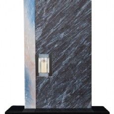 Ein schwarz-weißer Marmorgrabstein mit einer Kerze darin.