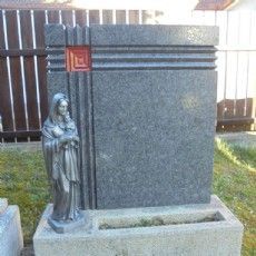 Ein Grabstein mit der Statue einer Frau, die ein Baby hält.