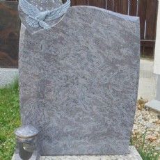 Ein Grabstein mit der Statue eines Adlers darauf.