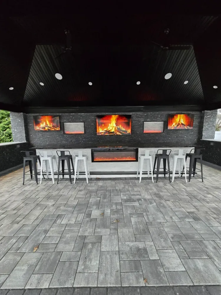 There is a fireplace in the middle of the room with stools around it.