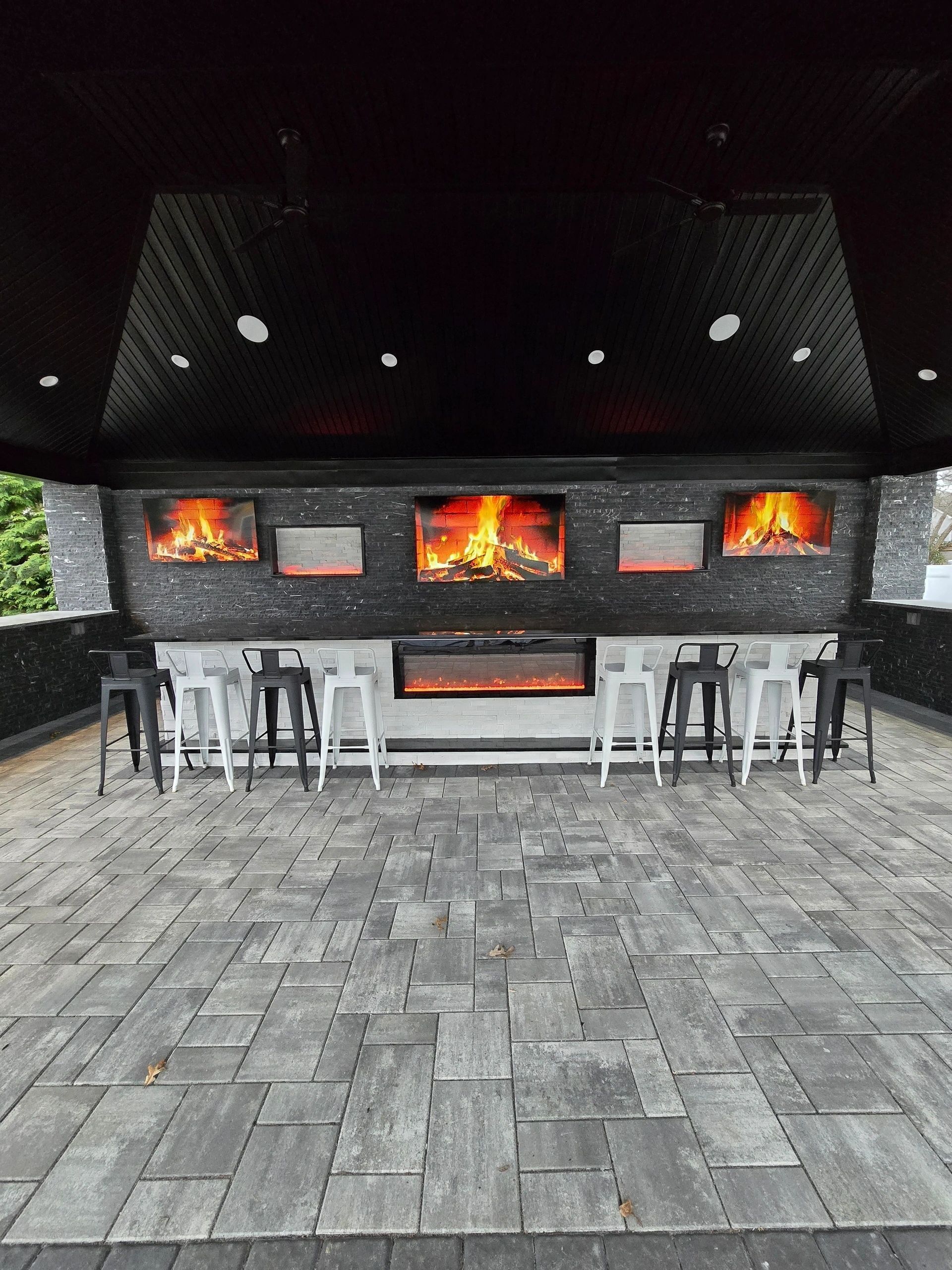 A patio area with a fireplace and stools