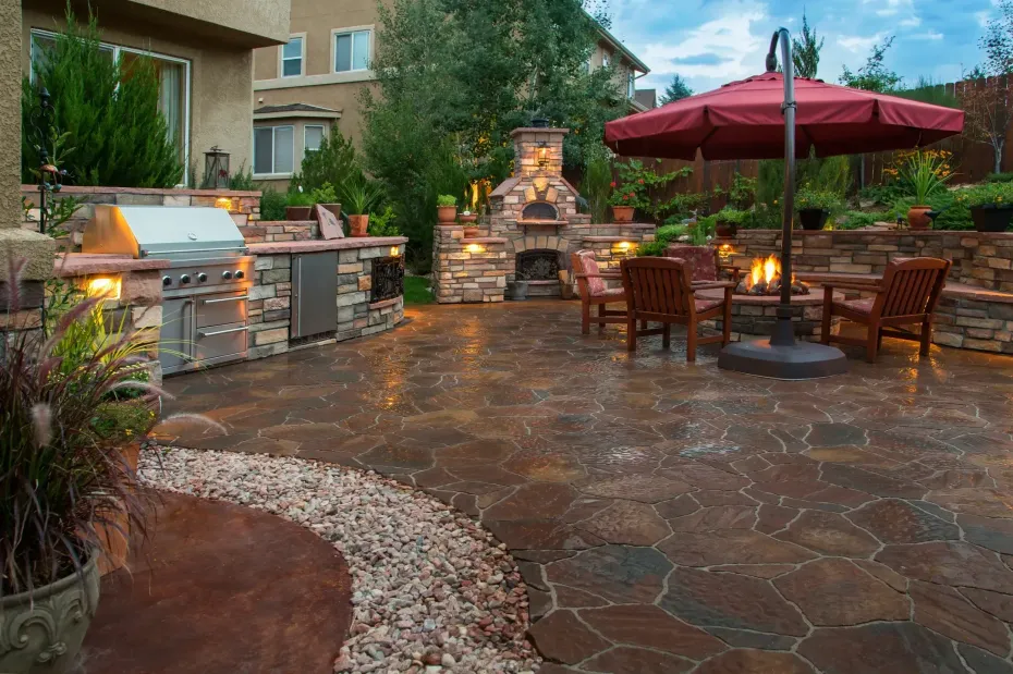 There is a red umbrella in the middle of the patio.