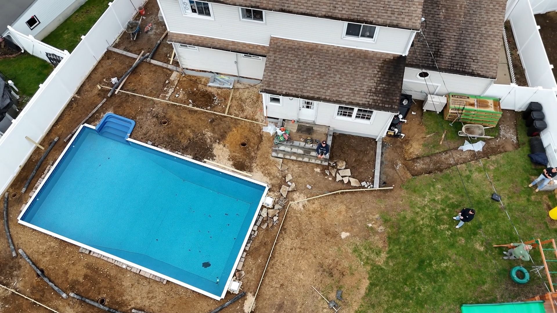 An aerial view of a house with a swimming pool in the backyard.