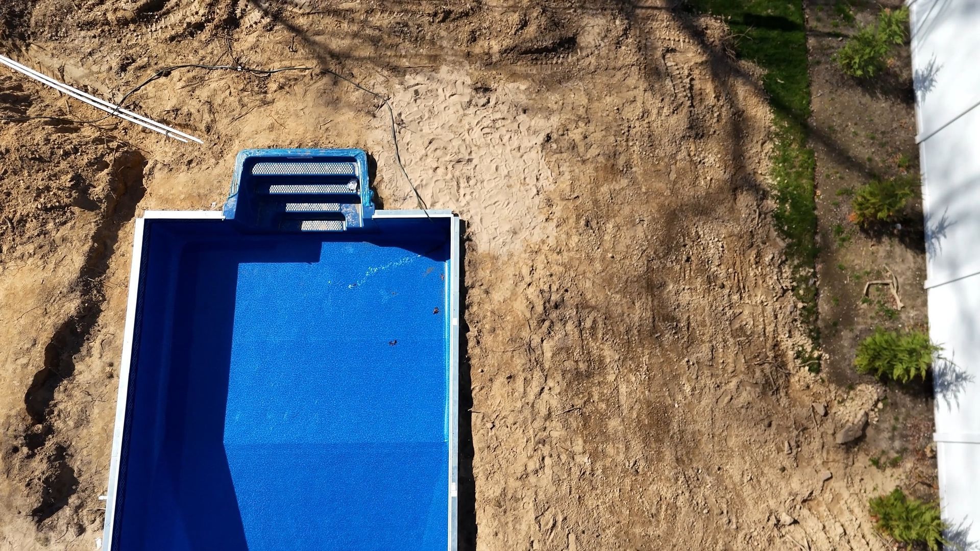An aerial view of a swimming pool being built in the dirt.