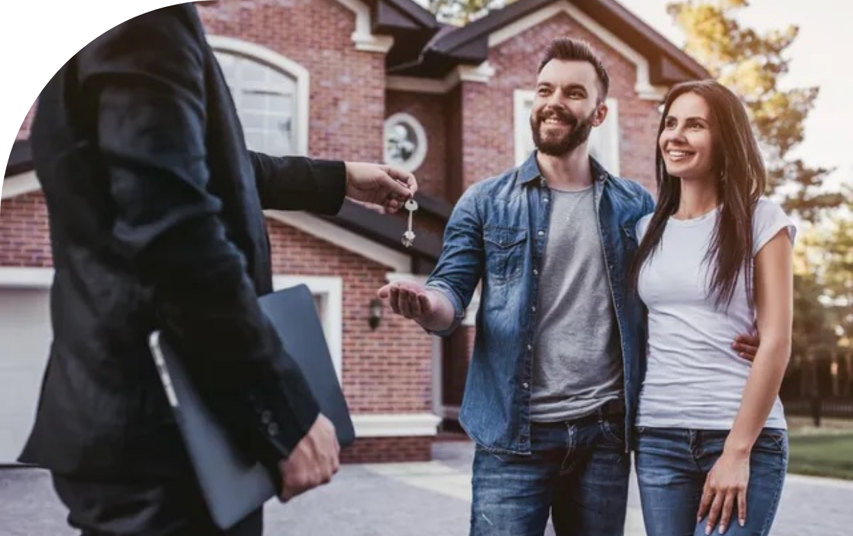 A man is giving a couple keys to their new house.