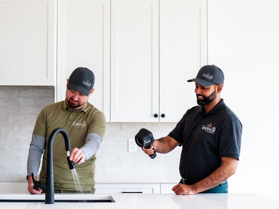 A man and a woman are sitting on a couch looking at a laptop.