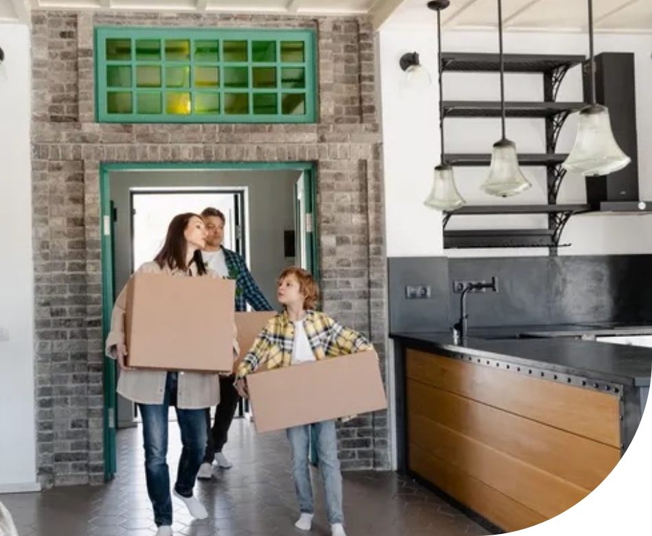 A family is moving into their new dream home, carrying multiple boxes. 