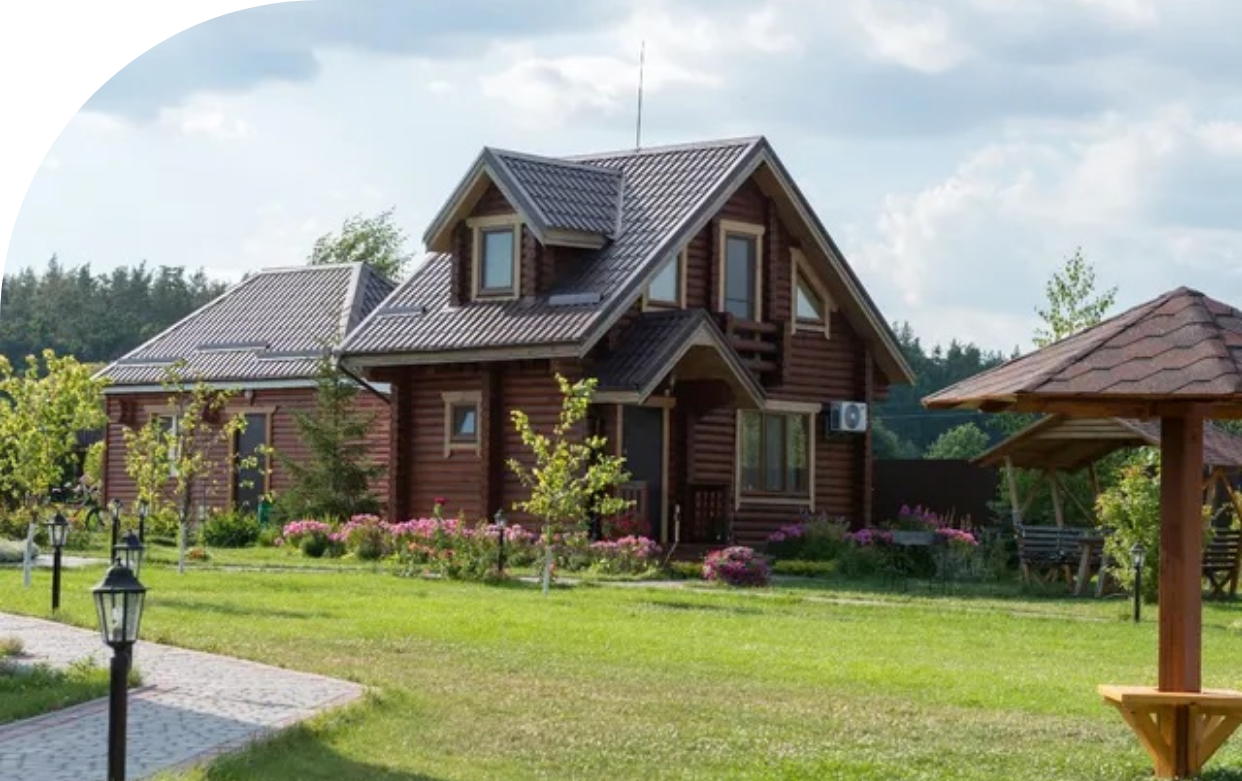 A large brown wooden house, with a big front yard.