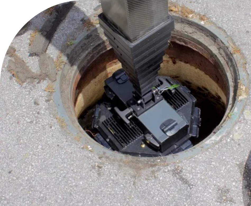 A manhole in the ground with a sewer scope in it.