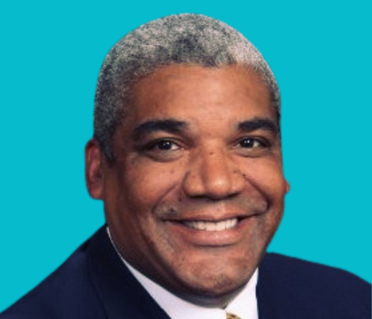 A man in a suit and tie is smiling on a blue background