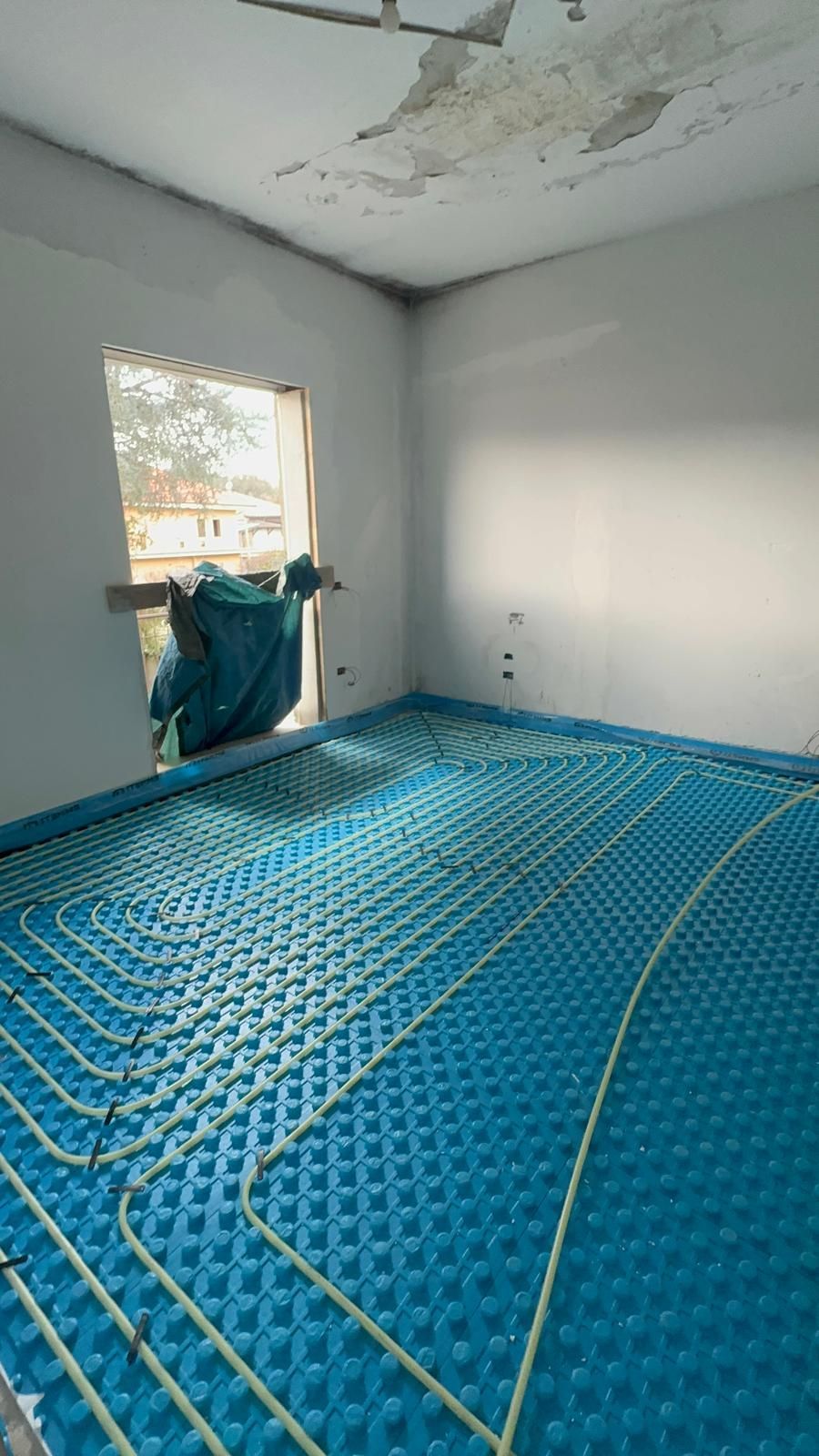 Una stanza con il pavimento blu e una finestra.