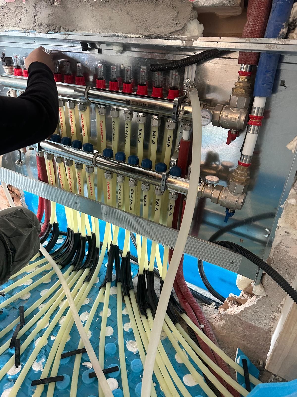 Una persona sta lavorando sul sistema di riscaldamento in una stanza.