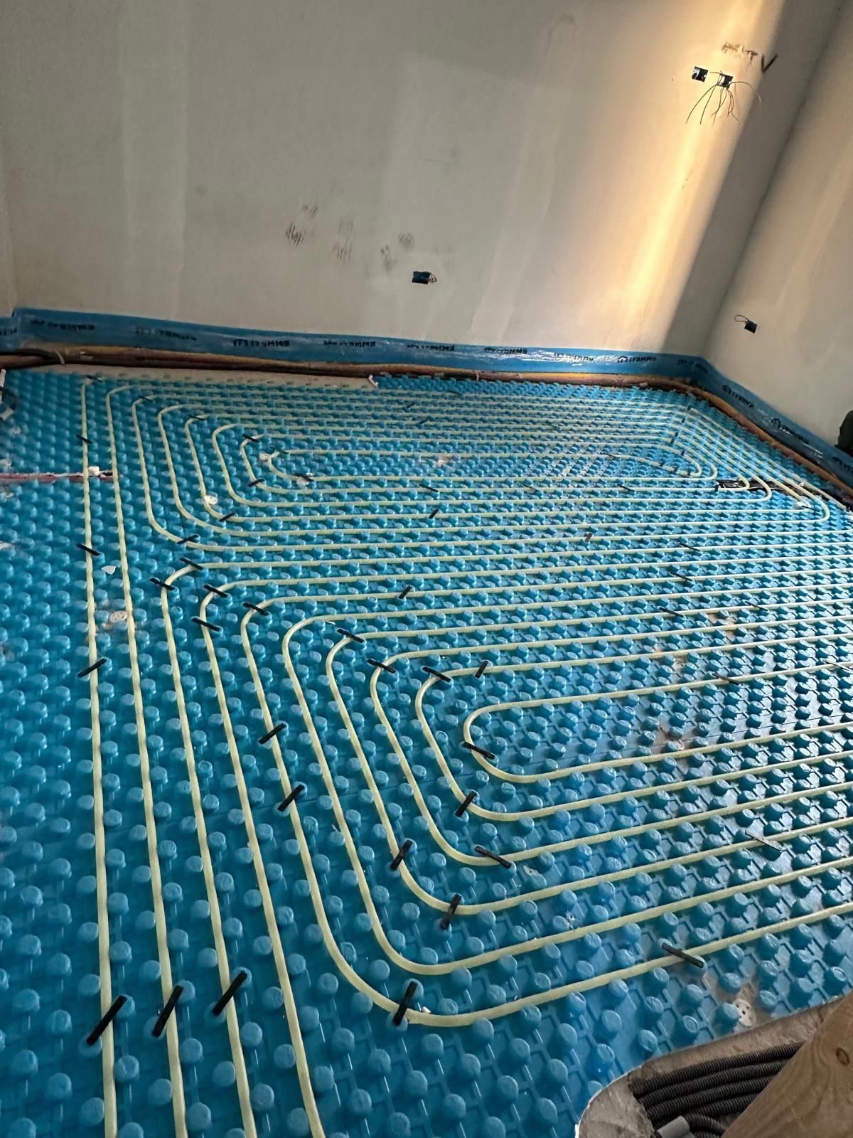 In una stanza è stato installato un sistema di riscaldamento a pavimento blu.