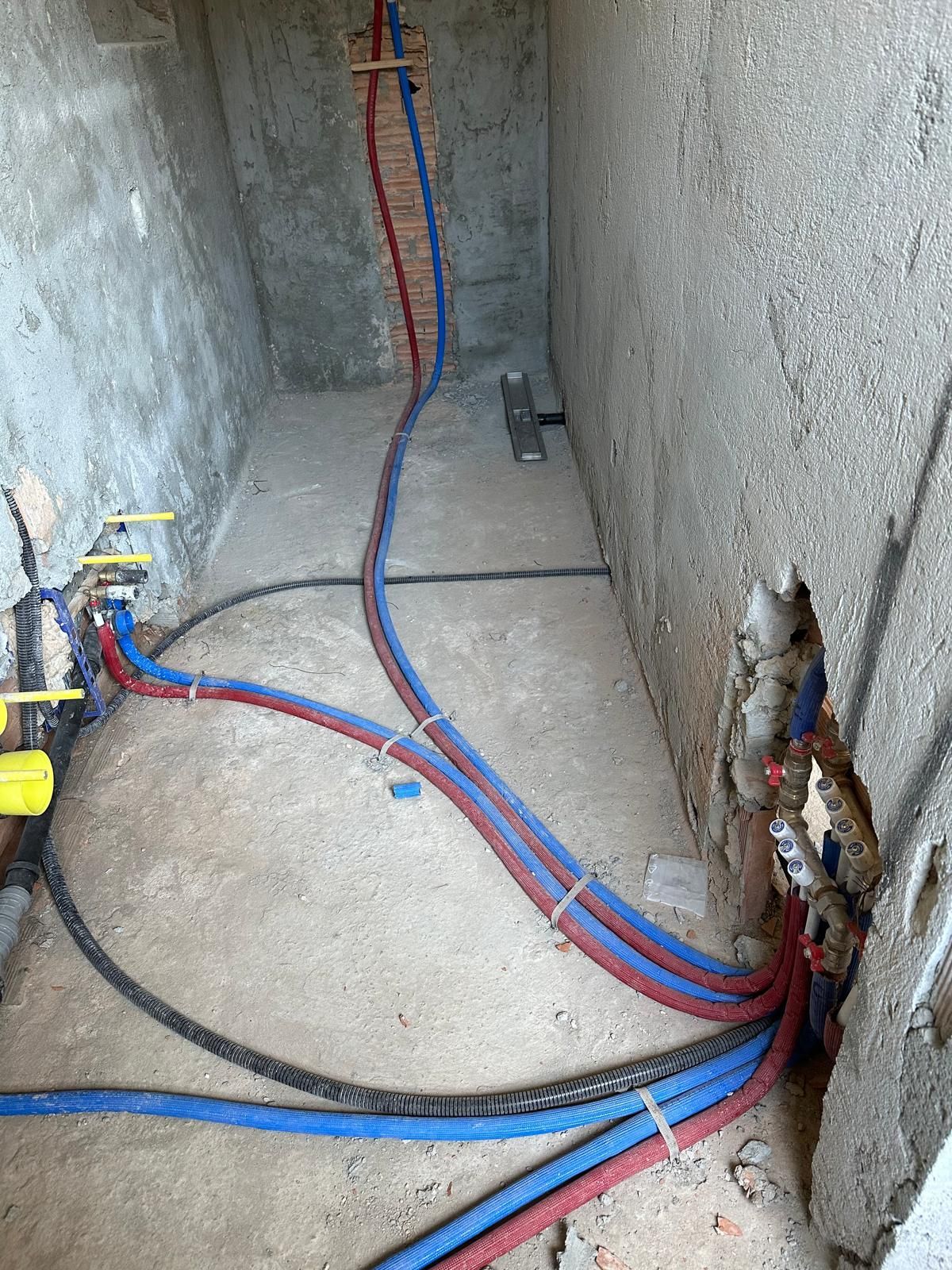 Un mucchio di fili sono collegati a un muro in una stanza.