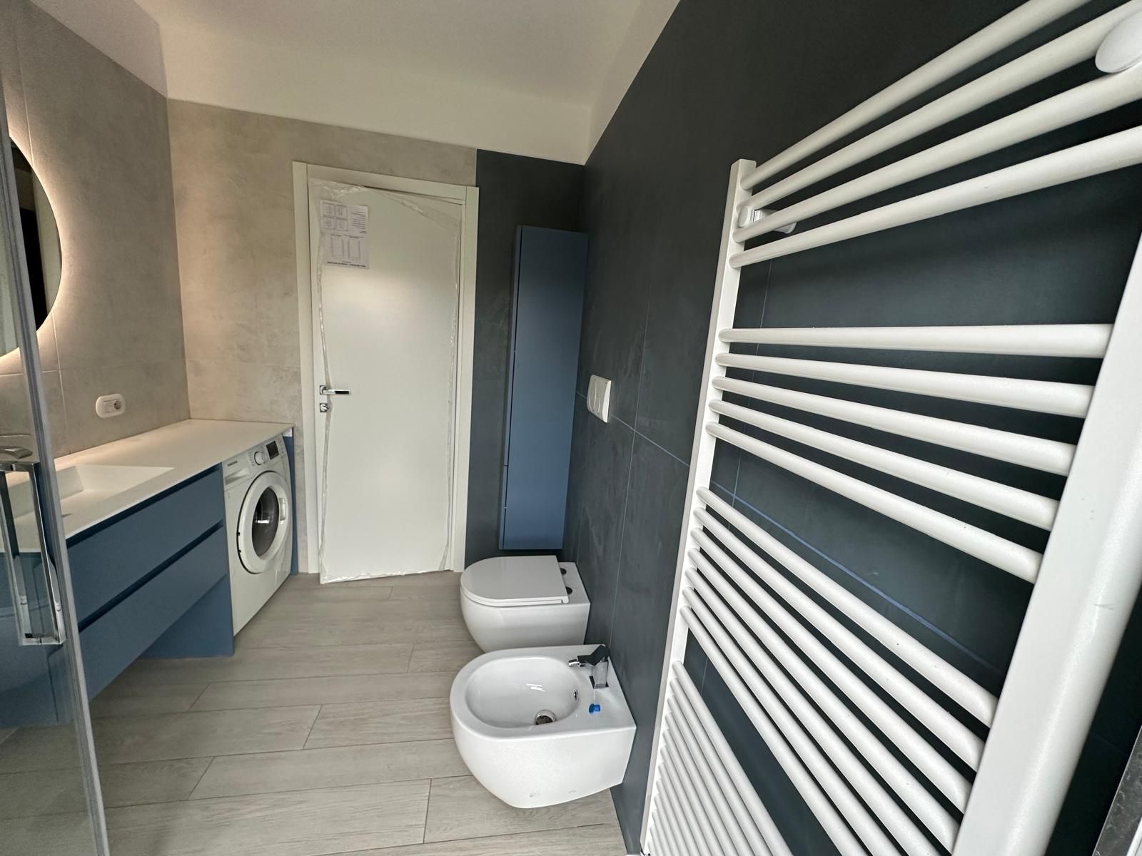 Un bagno con due WC e un portasciugamani.