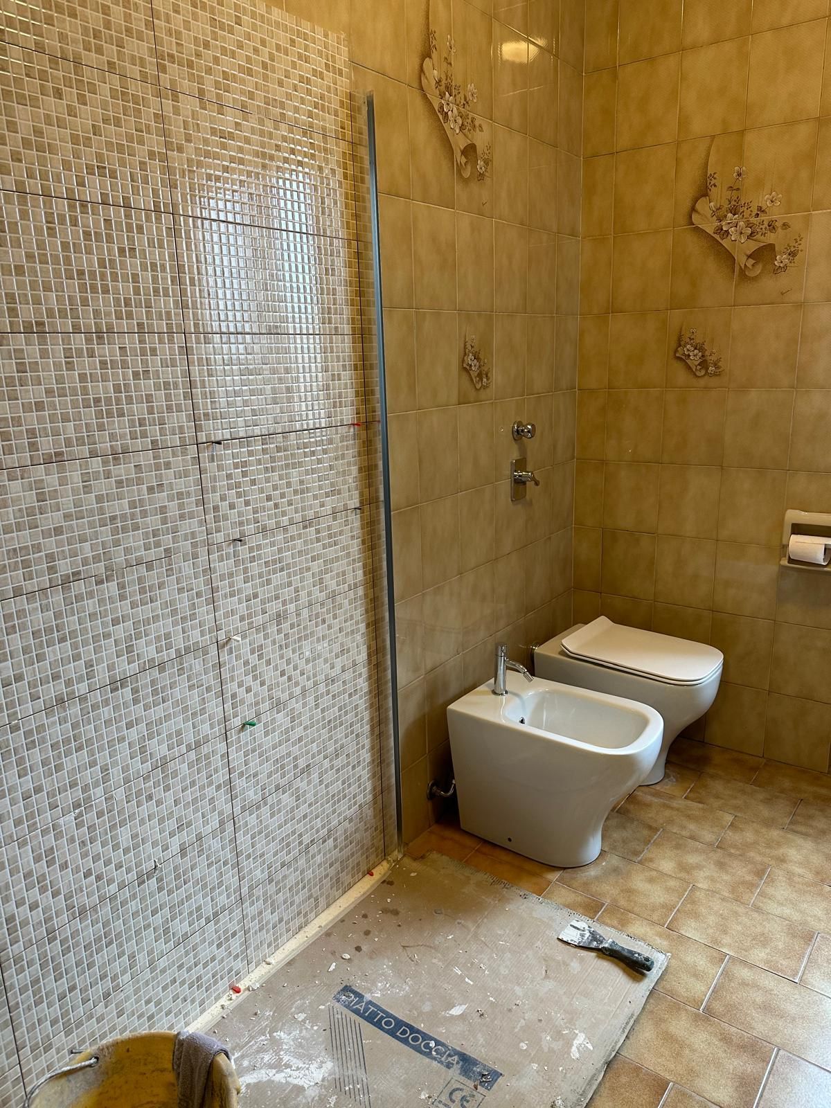 Un bagno con bidet, WC e doccia.