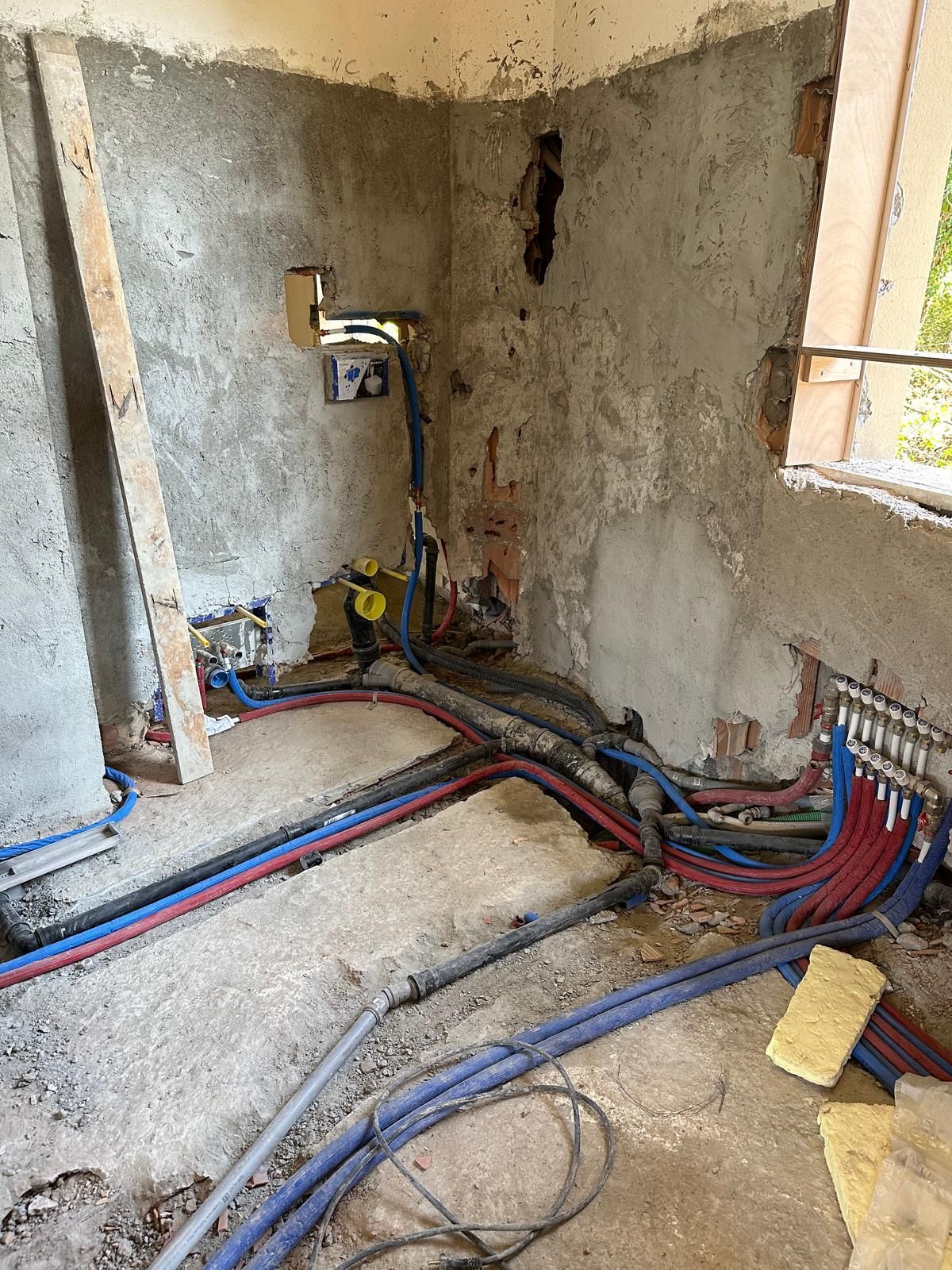 Un bagno in costruzione con un sacco di fili che escono dal muro.