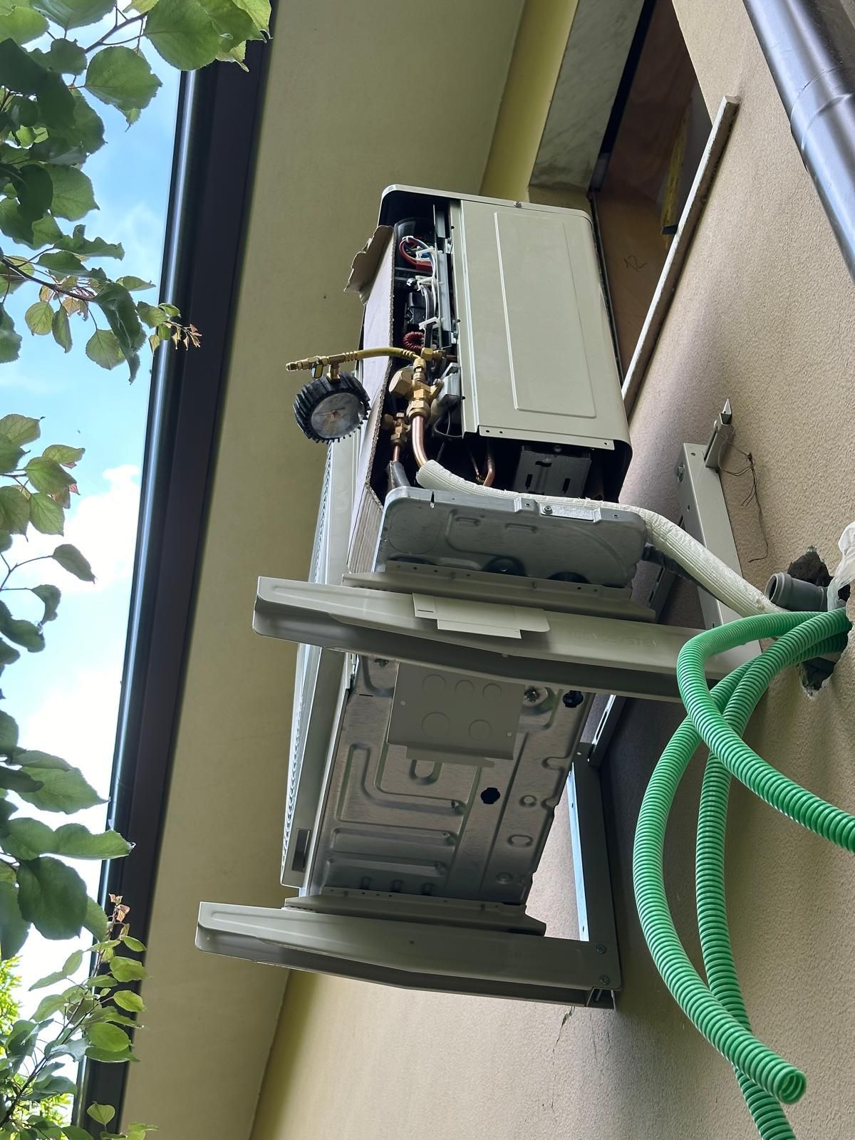 Un tubo verde è collegato a un condizionatore d'aria montato a parete.