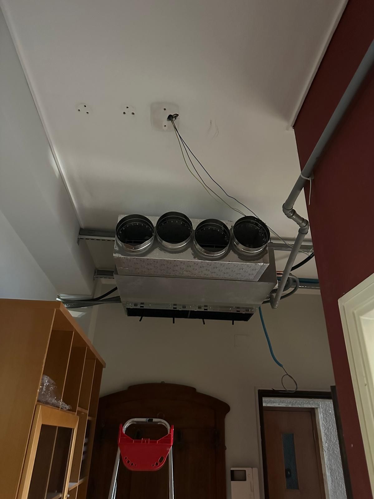 Una stanza con una scala e un ventilatore a soffitto.