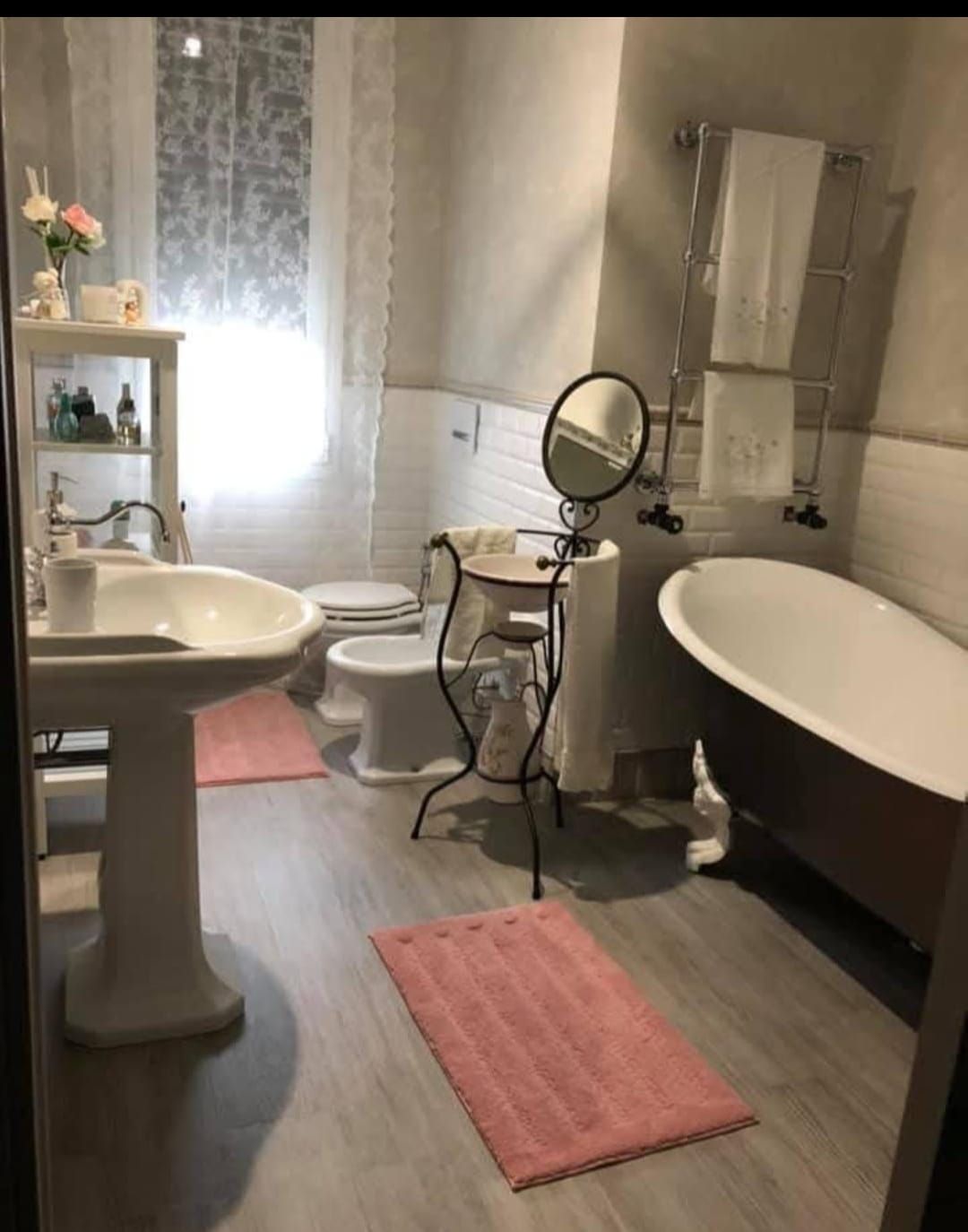 Un bagno con vasca, lavandino, WC e specchio