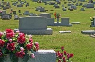 A cemetery filled with lots of graves and flowers.