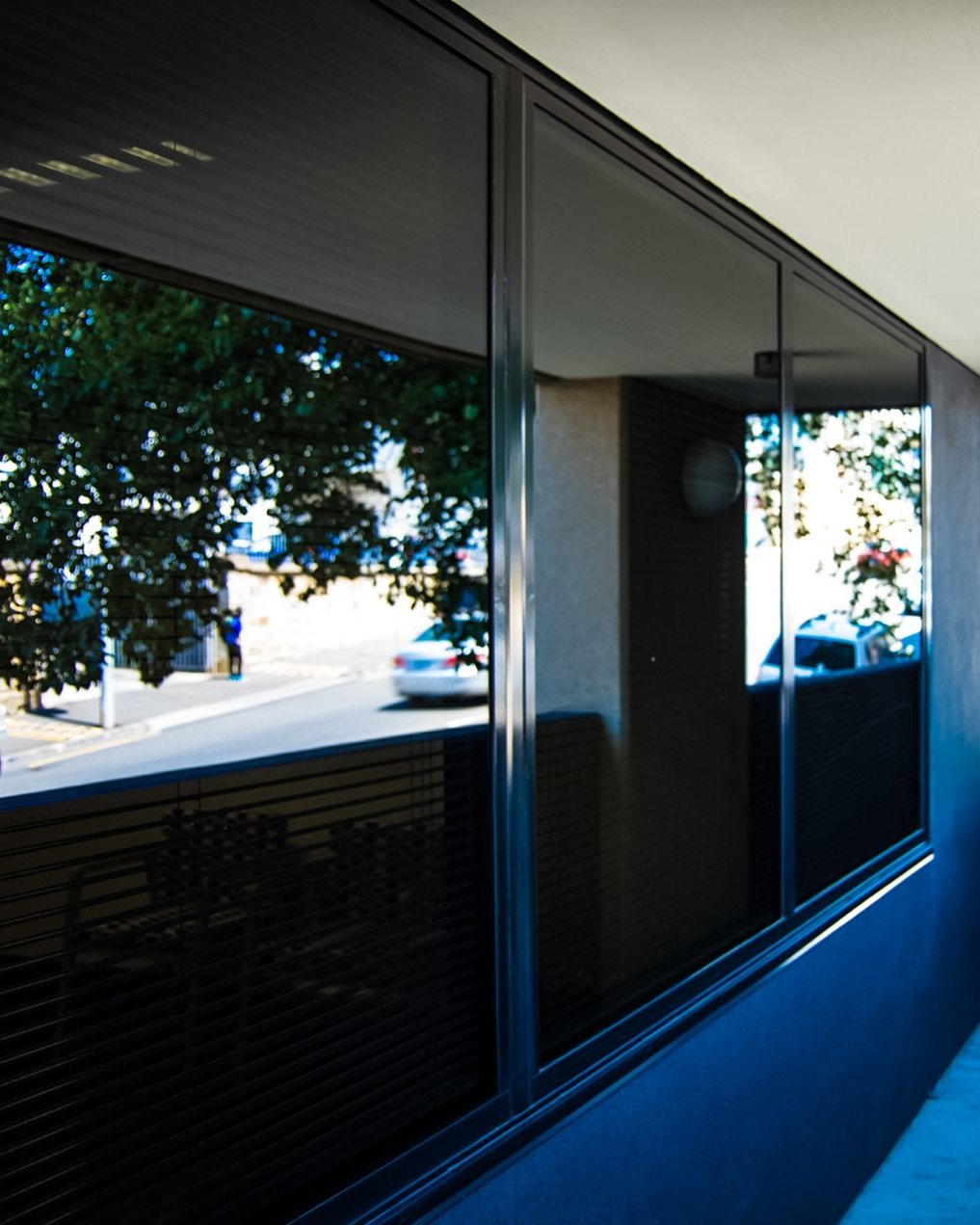 A man is cleaning the wheel of a black car with a sponge.