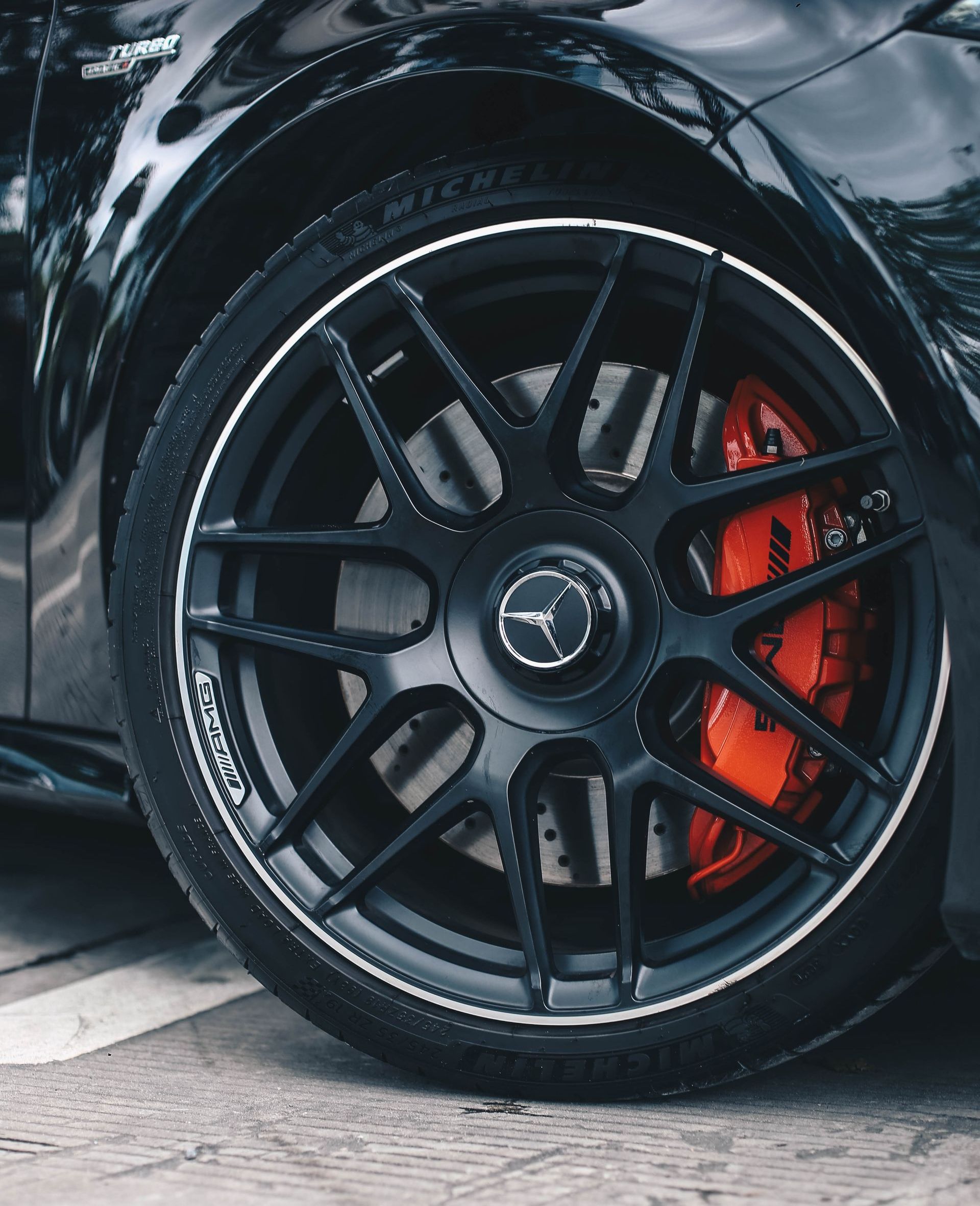 A person is wrapping a car with clear plastic