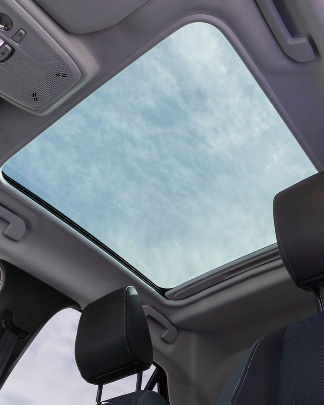 A person is applying a clear film to the hood of a car.