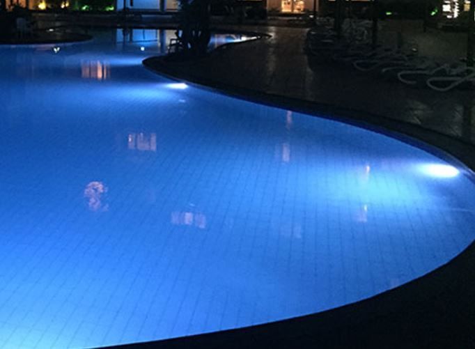 A Large Swimming Pool Is Lit Up At Night — Landsborough Pool Supplies & Service in Landsborough, QLD