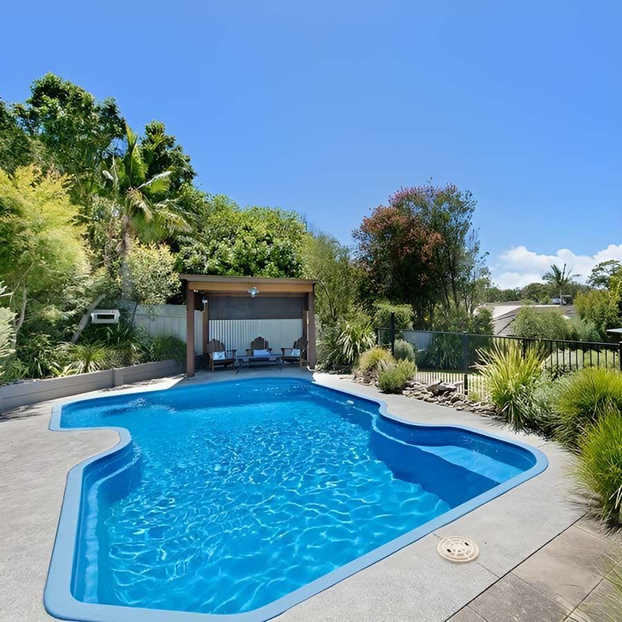 A Large Swimming Pool With A Gazebo In The Background — Landsborough Pool Supplies & Service in Landsborough, QLD