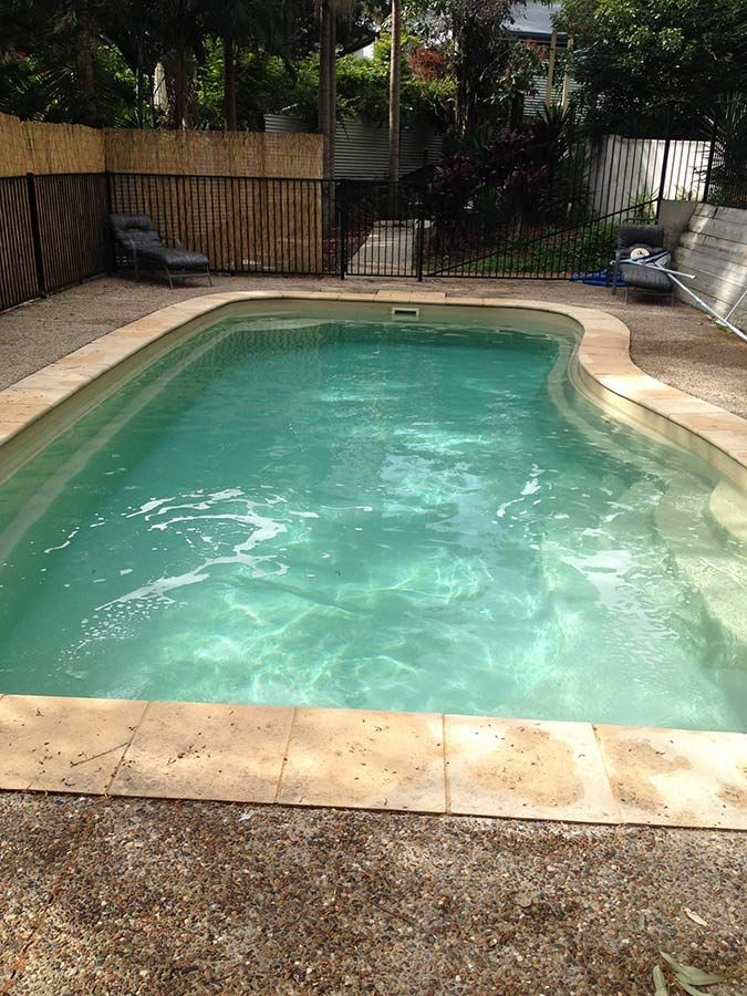 A Large Swimming Pool Filled With Green Water In A Backyard — Landsborough Pool Supplies & Service in Landsborough, QLD