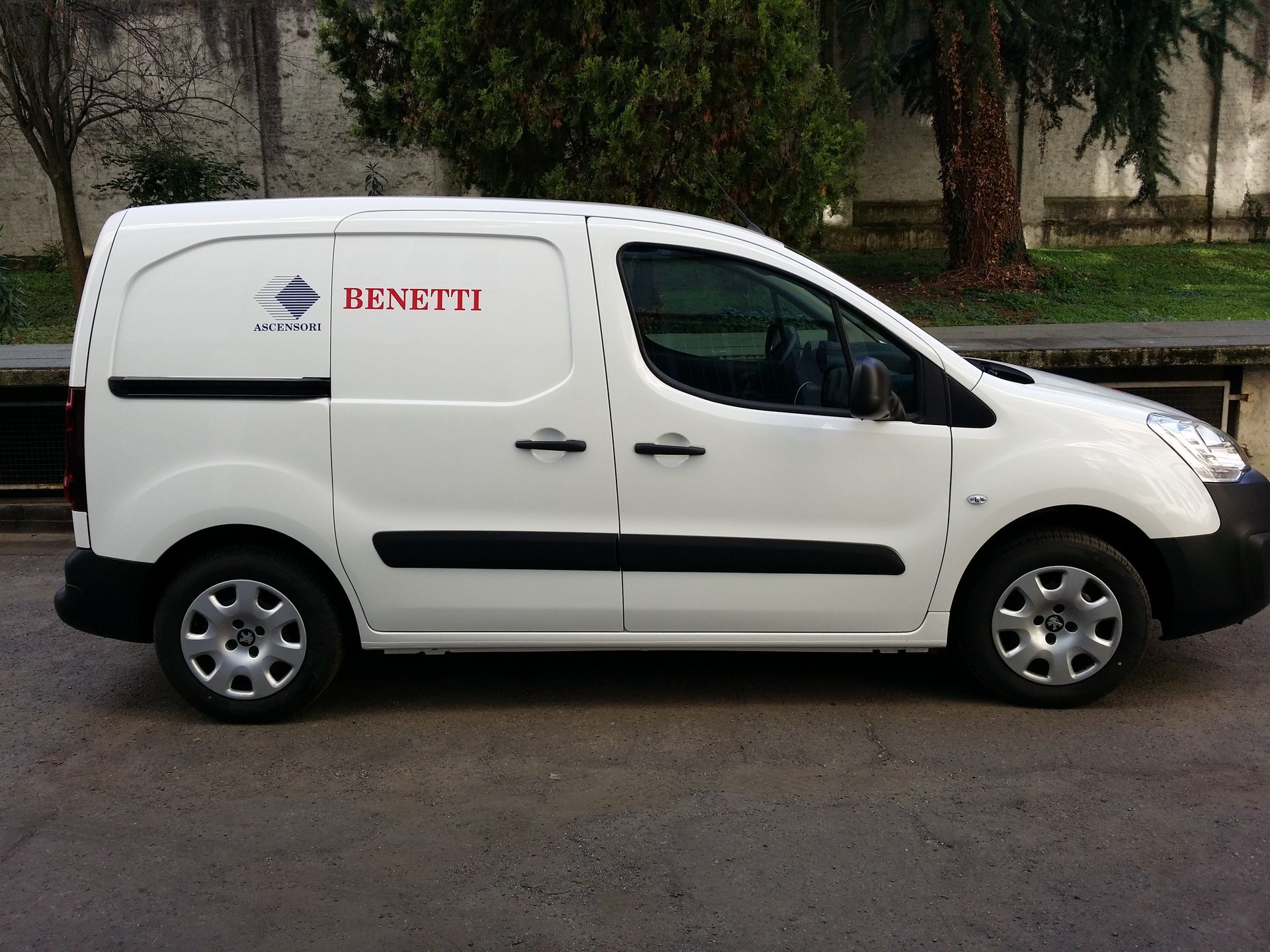 Un furgone bianco con la scritta benetti sul lato