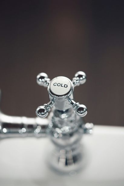 A close-up of a chrome bathroom faucet handle with 
