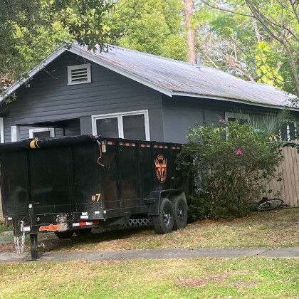 A dumpster is parked in front of a house.