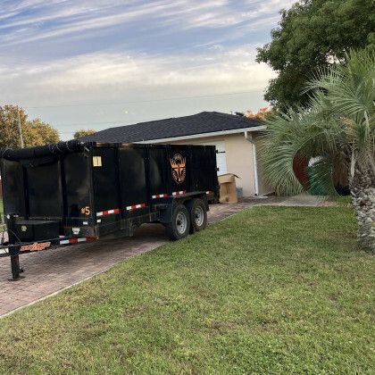 A dump truck is parked in a driveway next to a house.