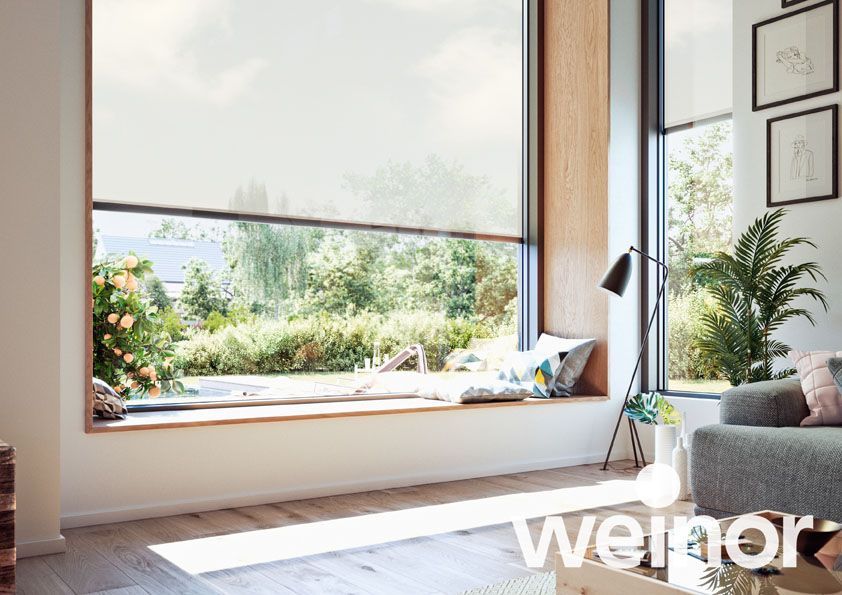 Ein modernes Haus mit Balkon und großem Fenster mit Jalousien.