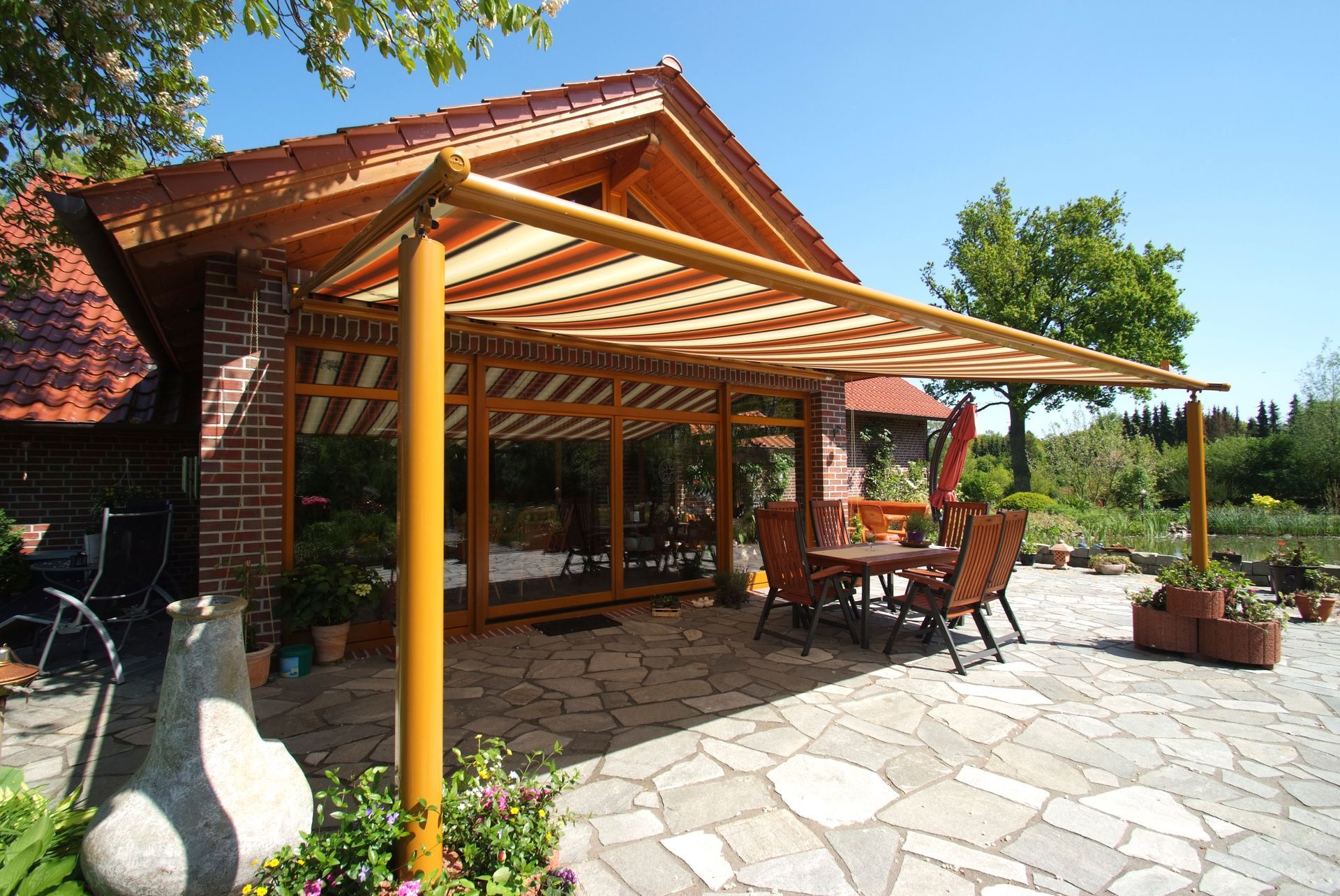 Eine Terrasse mit Tisch und Stühlen unter einer Pergola