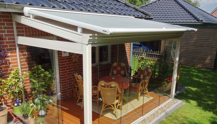 Auf der Veranda eines Hauses stehen ein Tisch und Stühle. Terrassendach von Terrassenwelten Frank Merz