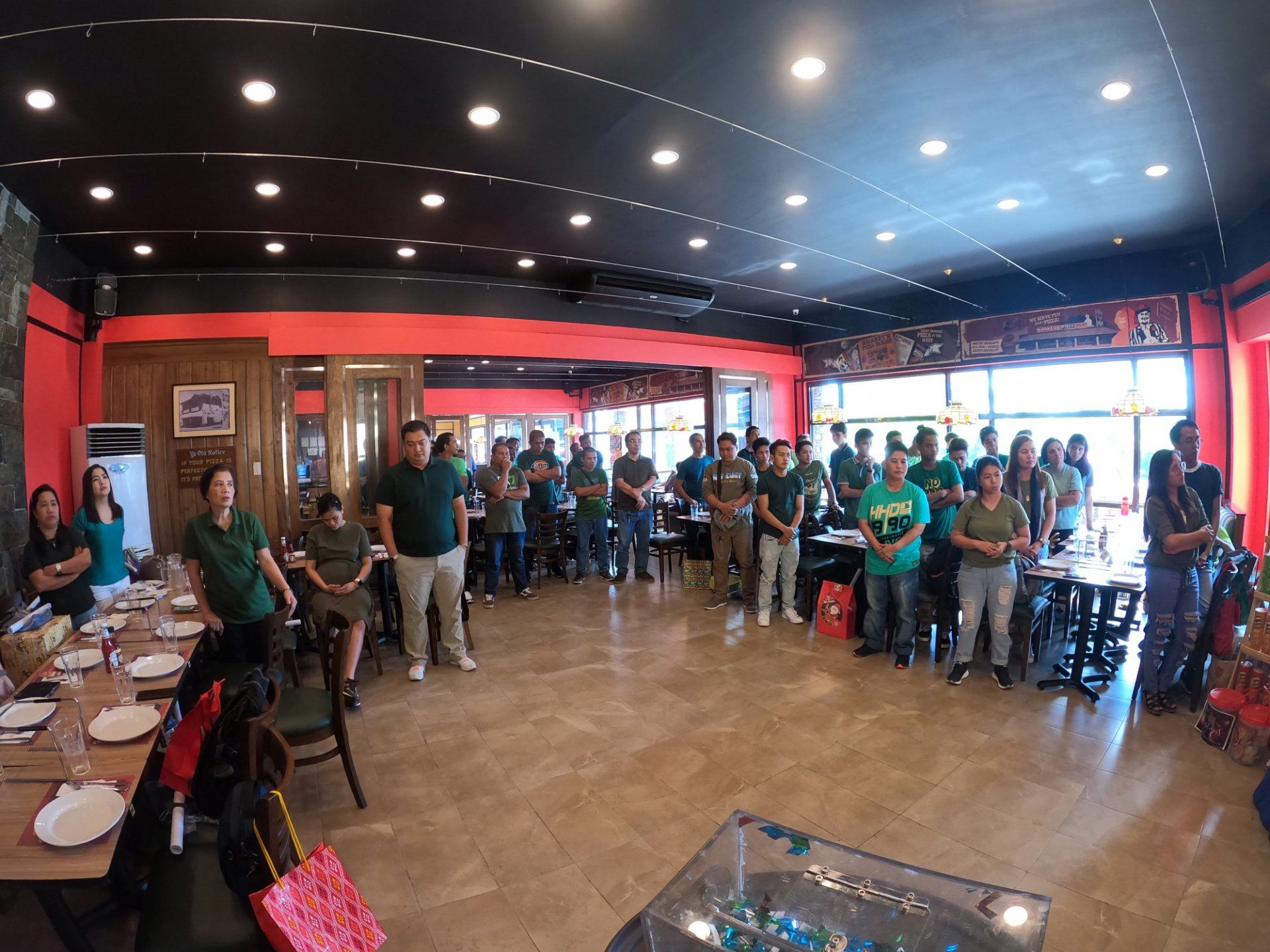A large group of people are standing in a restaurant.