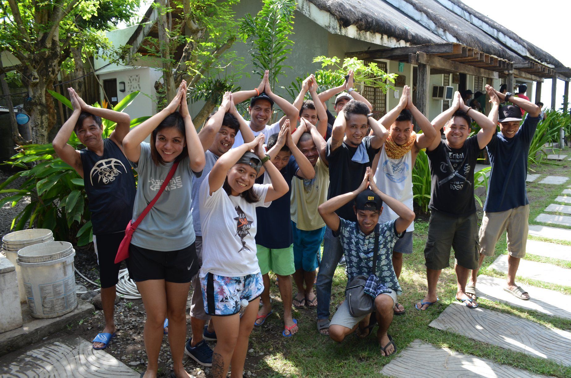 A group of people are posing for a picture with their hands in the air.
