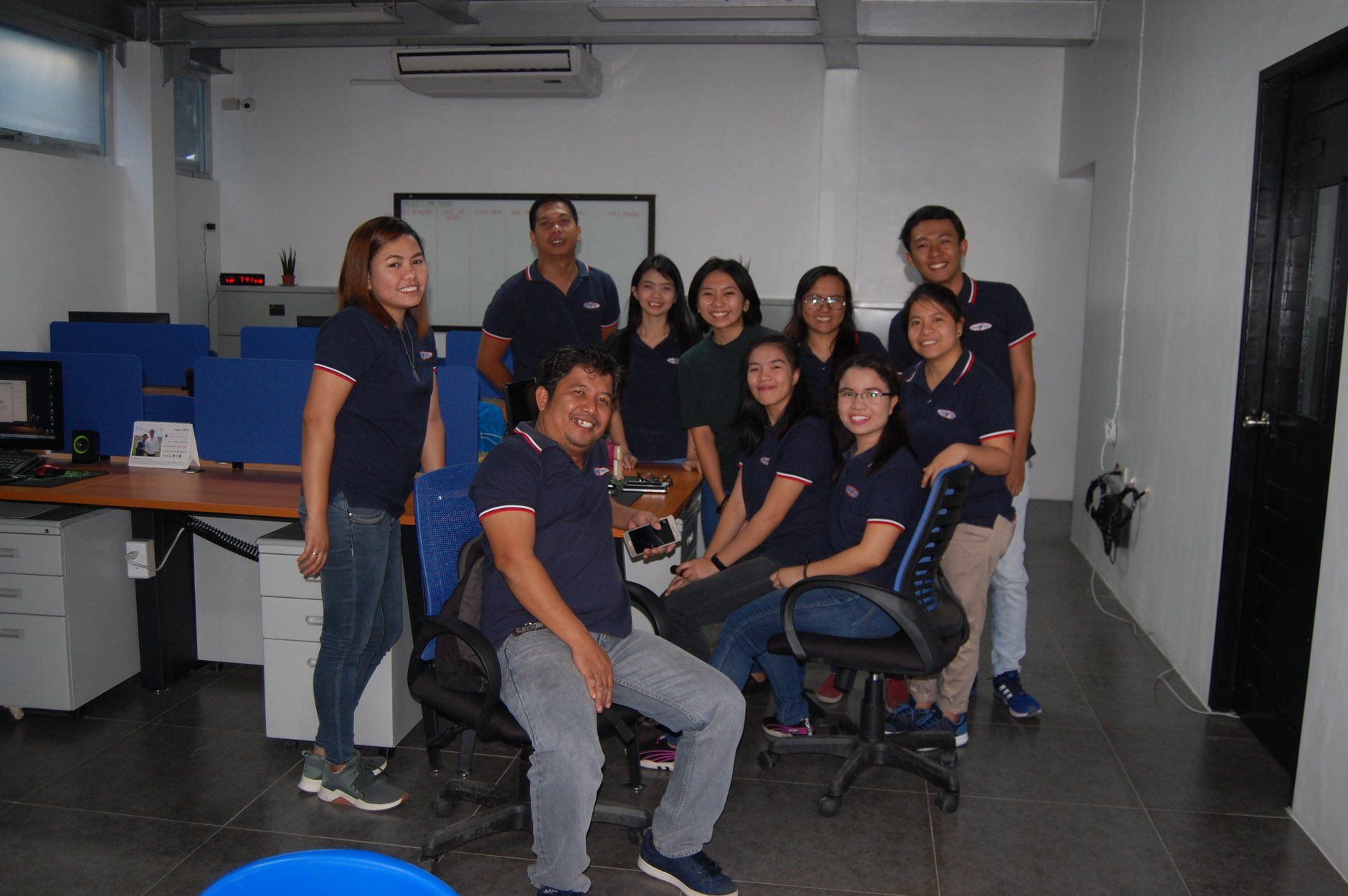 A group of people are posing for a picture in an office.