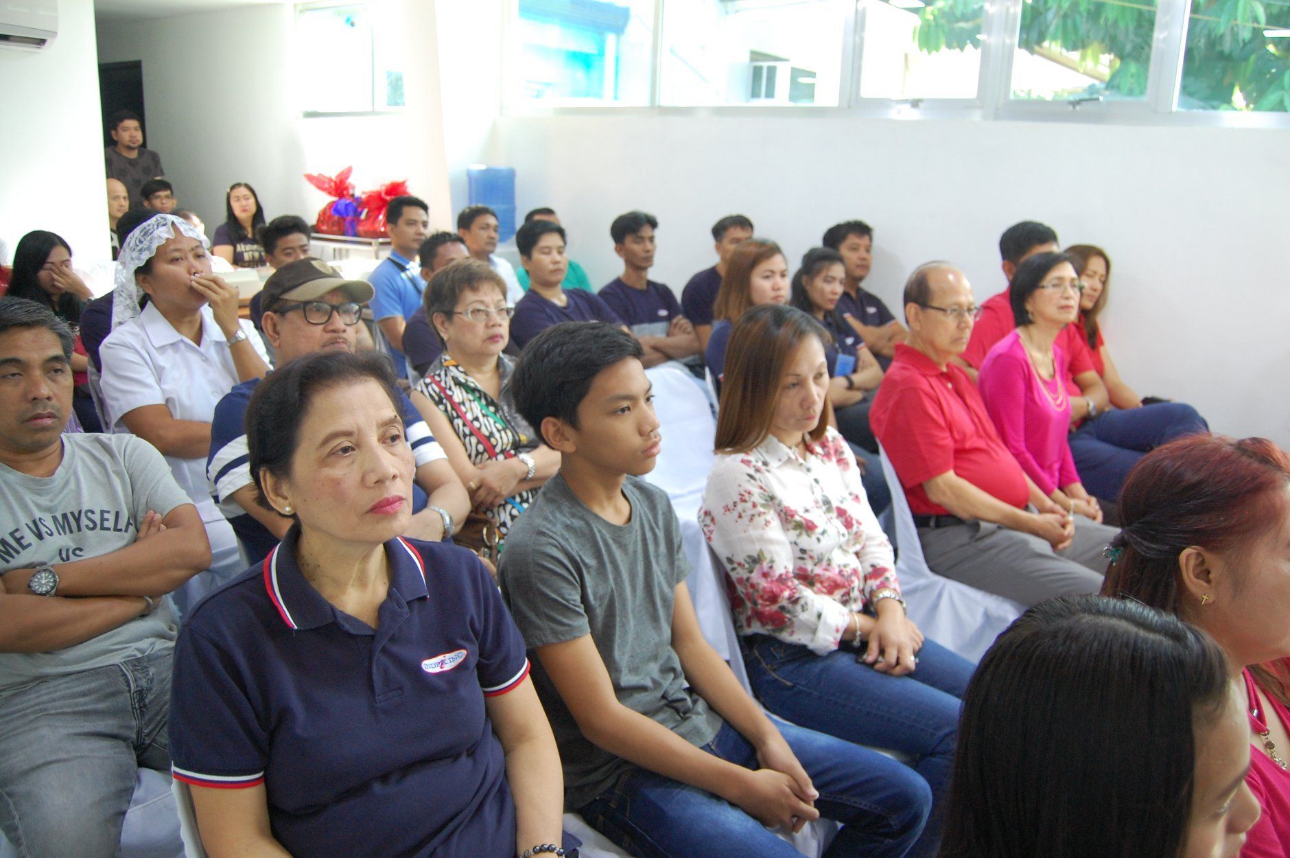 A group of people are sitting in a room watching a presentation.