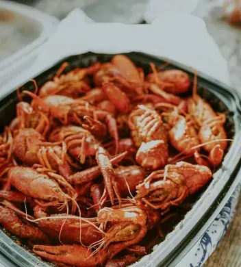 A close up of a tray of crawfish on a table.