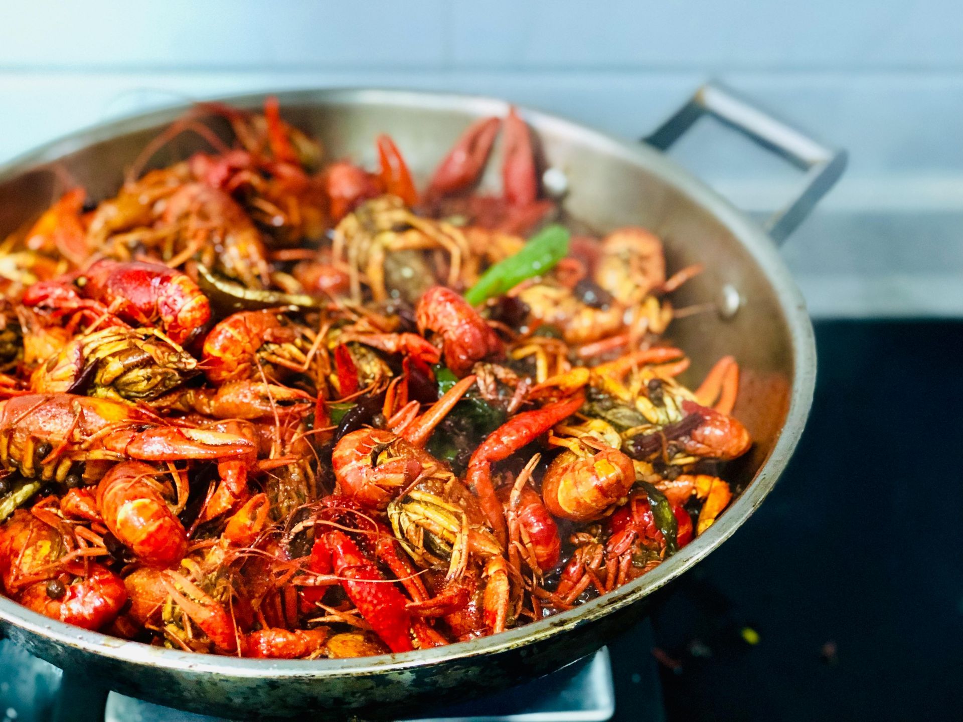 A pan filled with crayfish and shrimp is cooking on a stove.