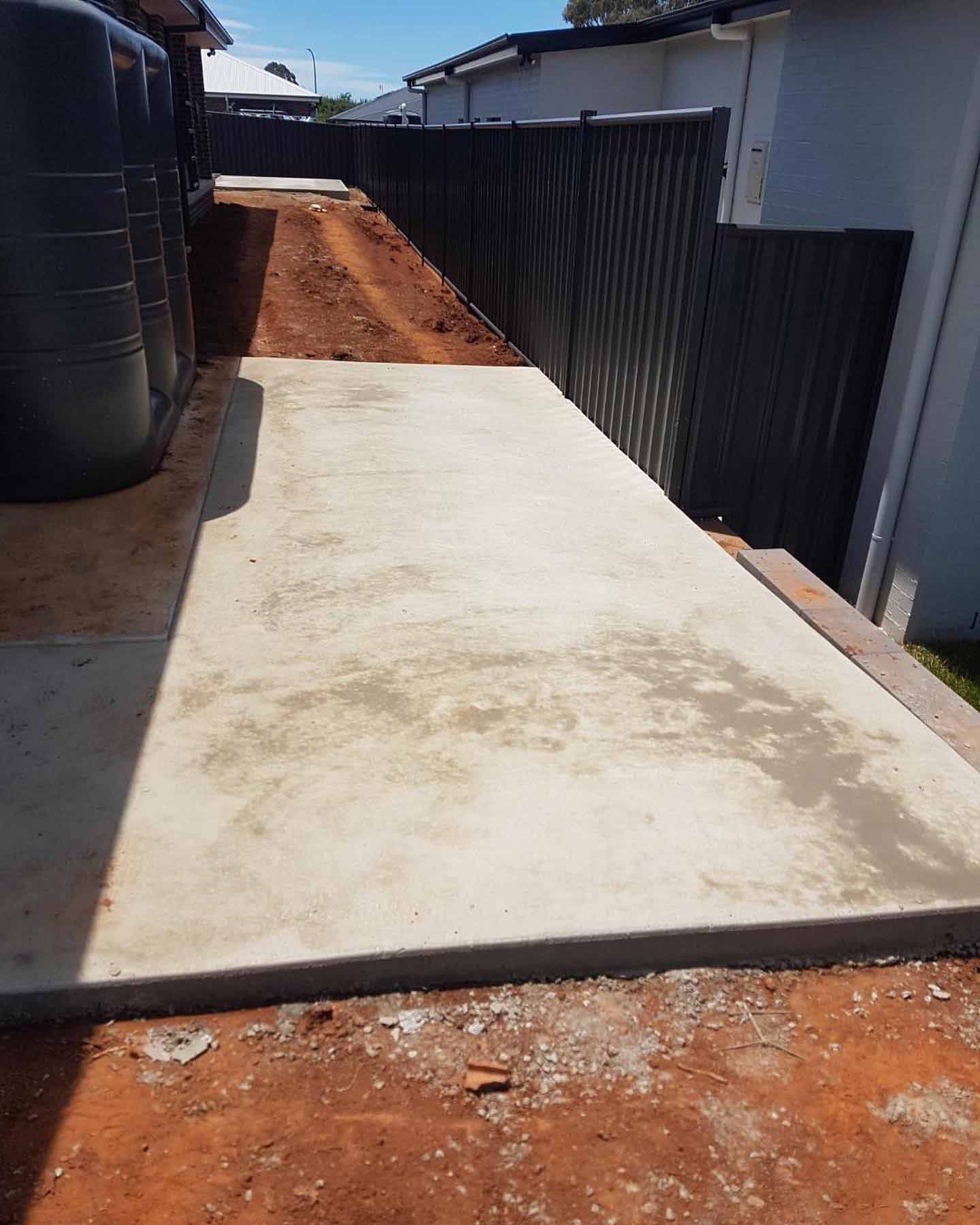 A Concrete Walkway Is Being Built In The Backyard Of A House — Regional Concreting Solutions In Molong, NSW