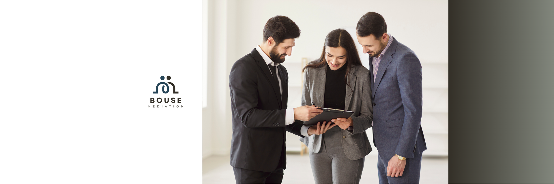 Three business professionals in suits standing together and looking at a document in an office setting.