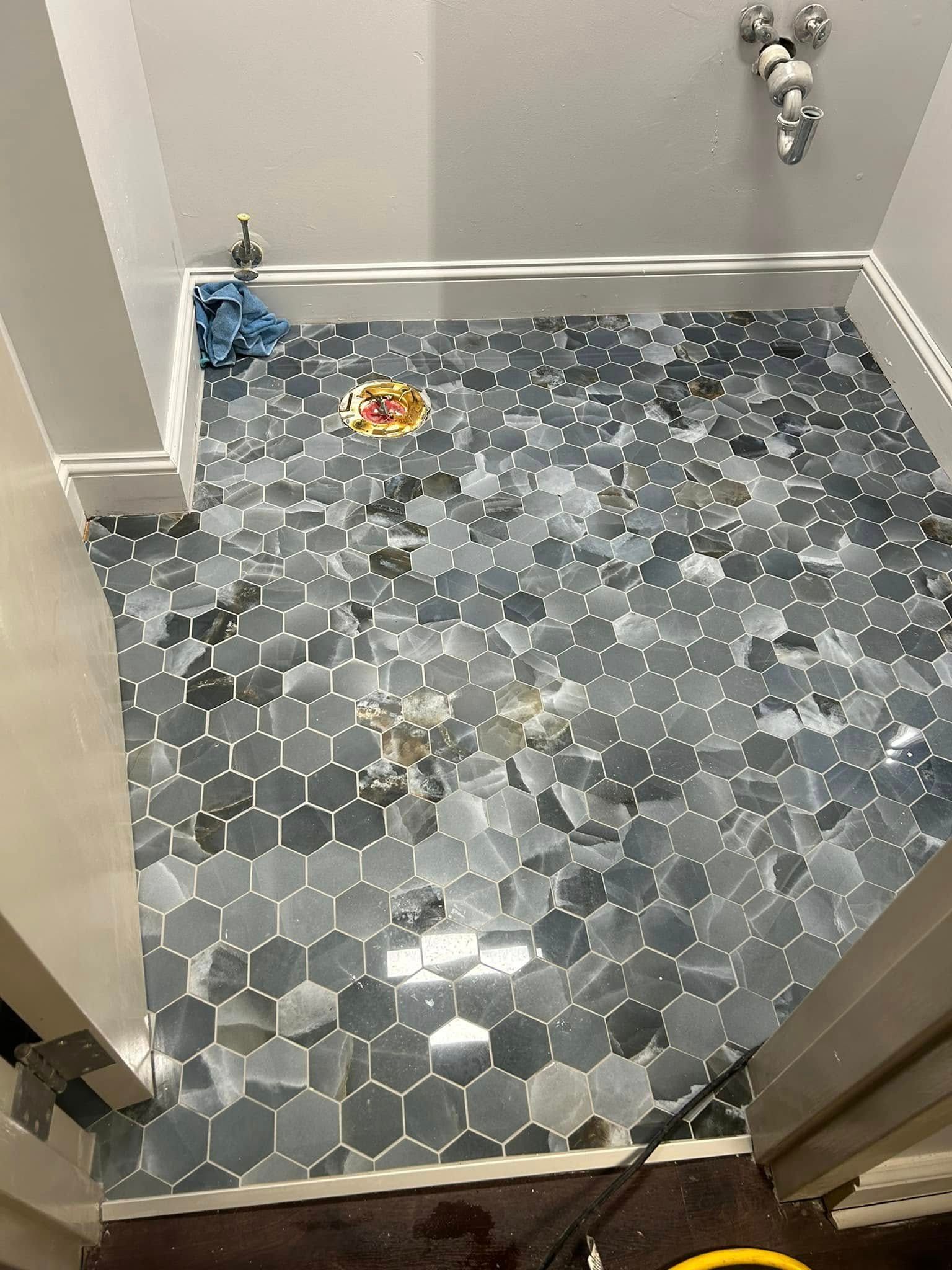 Hexagon tile bathroom floor in blue and gray tones.