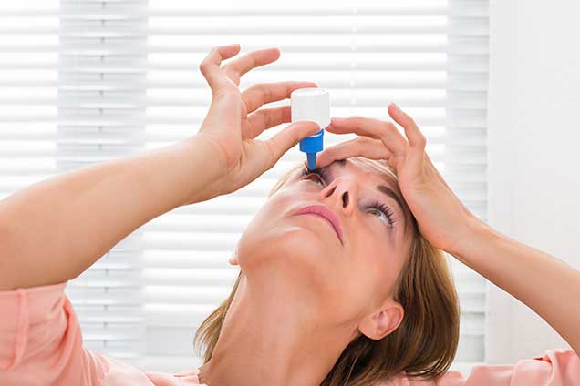 Woman Pouring Medicine Drops In Eyes