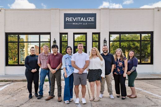 Revitalize Realty company staff standing in front of office building