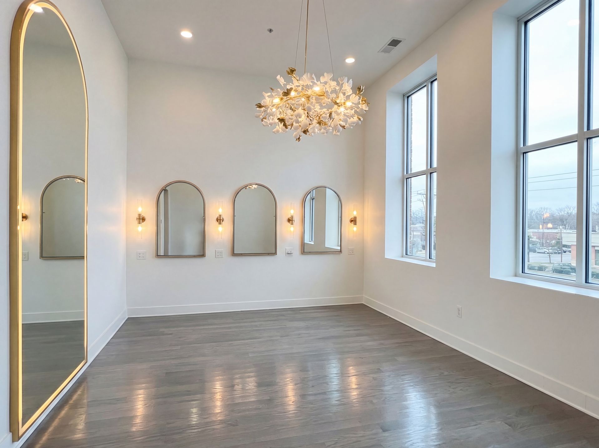 Luxurious white and gold room, decorated with flowers, features vanity, mirrors, and seating.